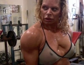 Bodybuilder Michelle Falsetta poses in the gym, stroking and massaging